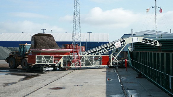 Cambered boom shiploader loading aggregates to coaster vessel